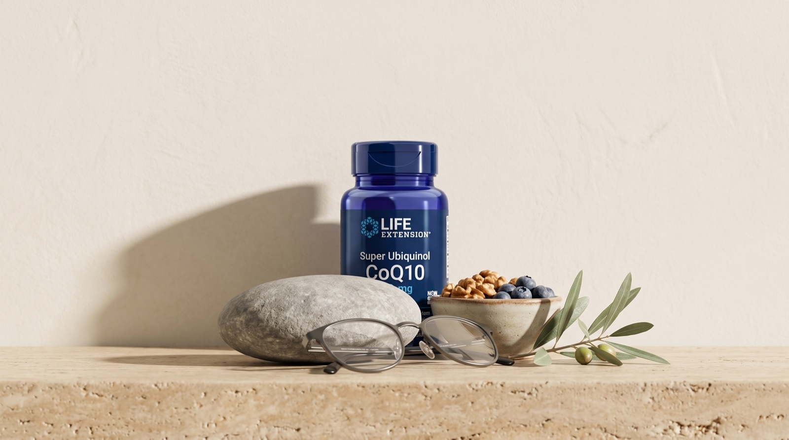 Super Ubiquinol CoQ10 Life Extension на травертине с очками, орехами и оливковой веткой